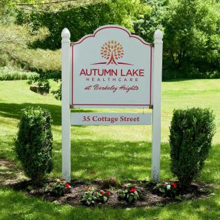 A sign for Autumn Lake Healthcare surrounded by a landscaped garden.