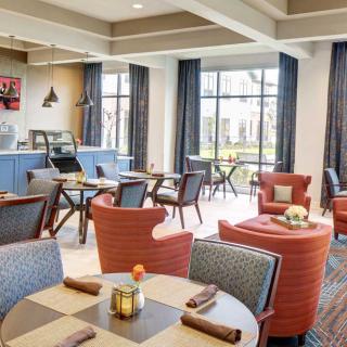 A cozy cafe interior with comfortable seating and large windows.