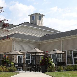 A modern building with a patio area featuring several umbrellas.