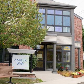 The entrance to a commercial building with a sign that reads 'Amber Way'.