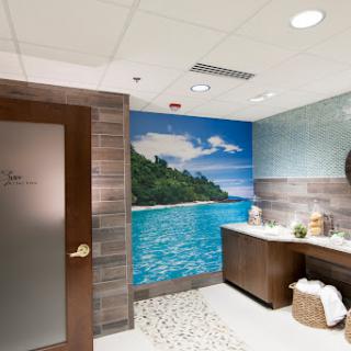 A serene spa bathroom featuring a tropical mural and modern amenities.