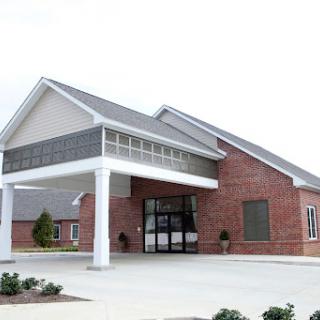 A modern brick building with a welcoming entrance and landscaped surroundings.