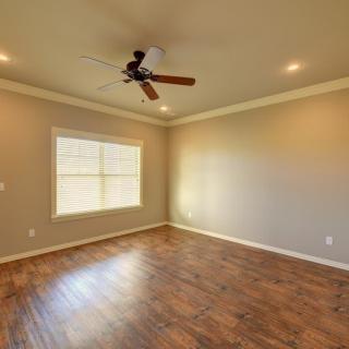 An empty room featuring hardwood floors, a ceiling fan, and recessed lighting.