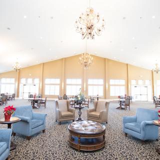 A spacious lounge area with comfortable seating and elegant chandeliers.