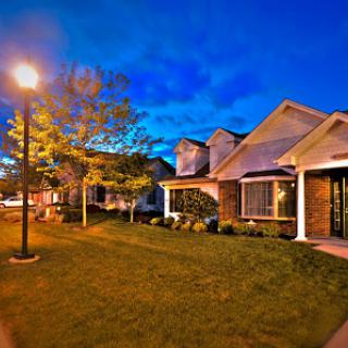 A picturesque residential neighborhood illuminated by street lights at dusk.