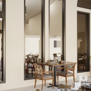 A stylish dining area featuring modern furniture and large windows.