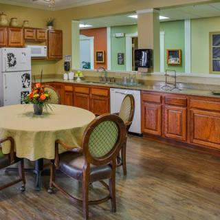 A cozy kitchen and dining area with wooden cabinets and a round table.