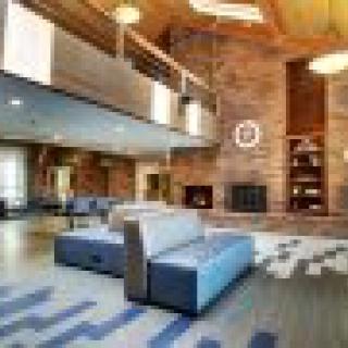 A modern, spacious lobby with comfortable seating and a large fireplace.