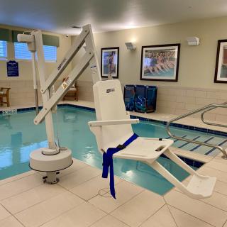 An indoor hotel pool equipped with an accessibility lift for disabled swimmers.