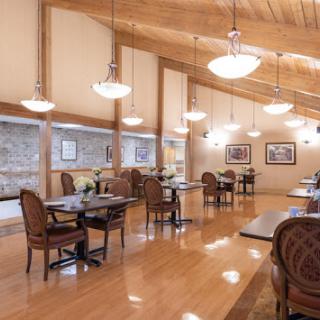 A spacious and inviting dining area featuring wooden floors and elegant lighting.