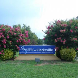 A welcoming sign for Clarksville surrounded by blooming flowers and greenery.