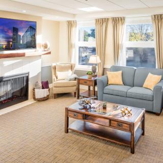 A cozy living room with a comfortable sofa, armchair, and a fireplace.