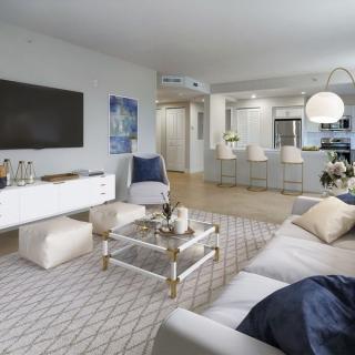 A modern living room with a stylish open kitchen and comfortable seating area.