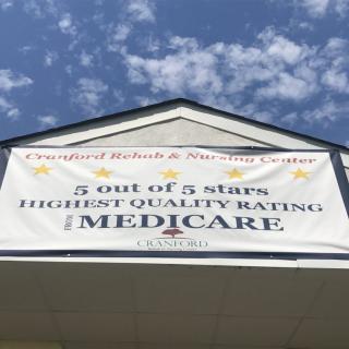 A banner on a building shows a Medicare rating of 5 out of 5 stars under a clear blue sky.