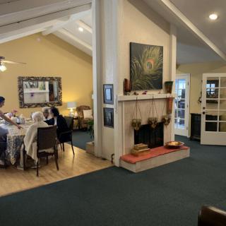A cozy dining room with a set table and a decorative fireplace.