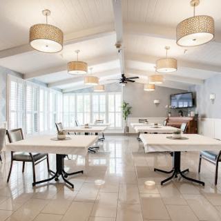 A modern dining area featuring elegant tables and chairs, illuminated by stylish pendant lights.