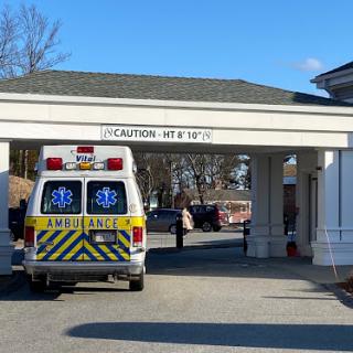 An ambulance parked at the entrance of a hospital, ready for emergency medical services.