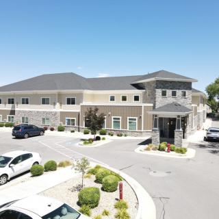 A modern commercial building with a parking lot on a sunny day.