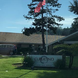 A sign in front of a building with an American flag.