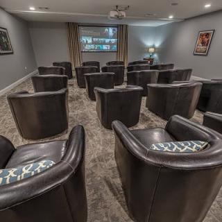 A cozy home theater with comfortable seating and a projector screen.