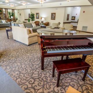 A well-furnished lounge with a grand piano and comfortable seating areas.