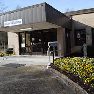 A well-maintained building entrance surrounded by colorful flowers.