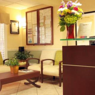 A cozy waiting room with comfortable seating and decorative flowers.