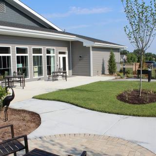 A modern building with a landscaped patio and outdoor seating area.