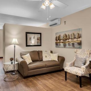 A cozy living room with a sofa, armchair, and elegant decor.