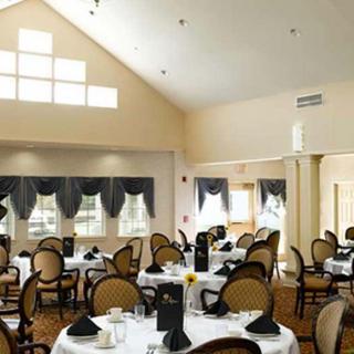 A well-lit dining room with elegantly set tables and classic decor.