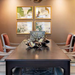 A well-decorated dining room featuring a modern table and chairs, along with elegant artwork on the wall.