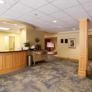 A spacious hotel lobby with a reception desk and cozy waiting area.