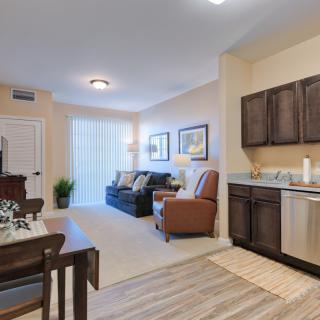 A modern apartment interior with a cozy living room and kitchen area, featuring comfortable seating and stylish d�cor.