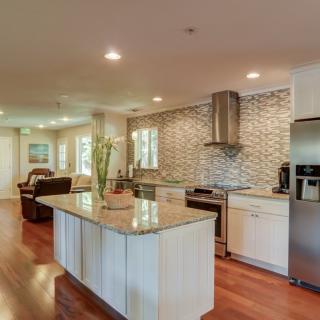 A modern kitchen with a spacious island, stainless steel appliances, and hardwood flooring.