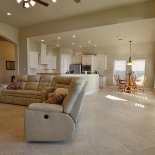 A modern open floor plan featuring a spacious living room, kitchen, and dining area with neutral color tones.