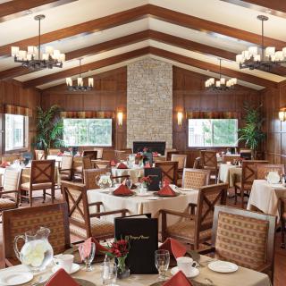 An elegant restaurant dining room with neatly arranged tables and a cozy fireplace.