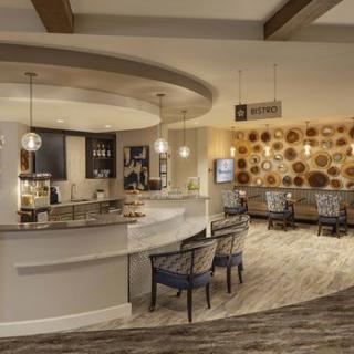 A modern lobby area featuring a stylish bar with comfortable seating and elegant lighting.