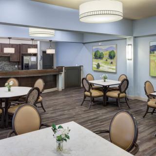 A modern dining area with elegantly arranged tables and chairs, featuring stylish artwork on the walls.