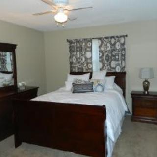 A cozy bedroom with a wooden bed, dresser, and decorative elements.