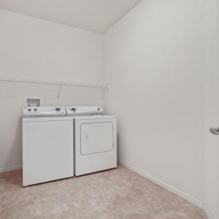 A spacious laundry room with a washer and dryer.