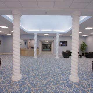 A spacious and modern lobby featuring twisted columns and a blue patterned carpet.