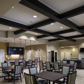 A modern dining area with neatly arranged tables and chairs, featuring stylish lighting.