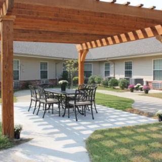 A cozy outdoor patio with a pergola and seating area.