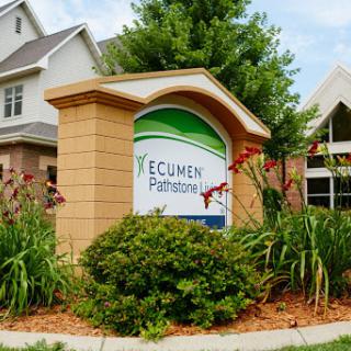 Entrance sign for Ecumen Pathways, surrounded by lush greenery.