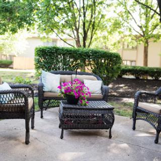 A cozy outdoor seating area surrounded by lush greenery, perfect for relaxation.