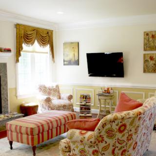 A cozy and elegantly decorated living room featuring a comfortable sofa, armchair, and a modern television, with warm lighting and tasteful d�cor.