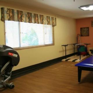 A fitness room with exercise equipment and a large window.