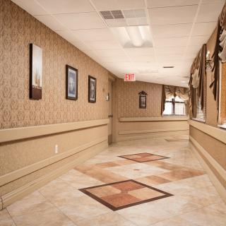A well-decorated hallway with framed pictures lining the walls and a patterned carpet.