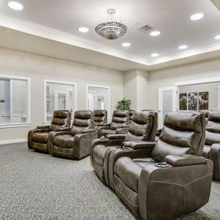 A luxurious home theater room with multiple recliner chairs arranged for optimal viewing.