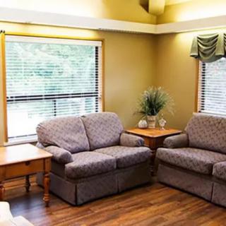 A cozy living room with two sofas, a table, and a window providing natural light.